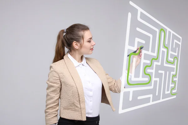 Junge Frau findet die Labyrinth-Lösung und schreibt auf Whiteboard. — Stockfoto