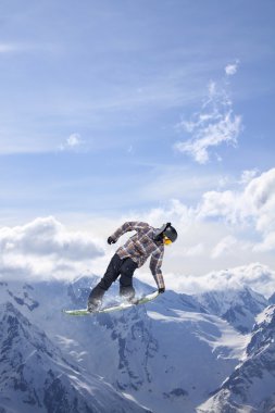 Dağlarda atlayan snowboard binicisi. Ekstrem snowboard serbest spor.