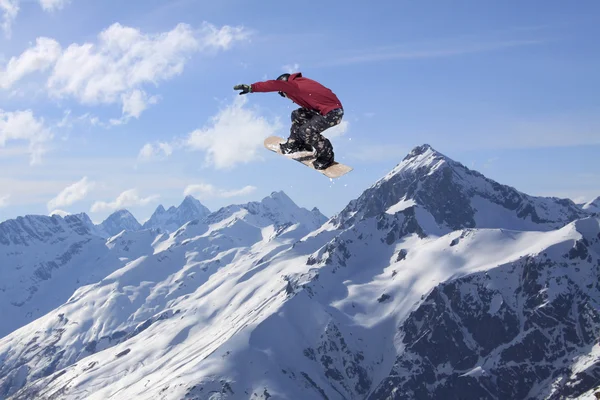 Dağlarda atlayan snowboard binicisi. Ekstrem snowboard serbest spor.