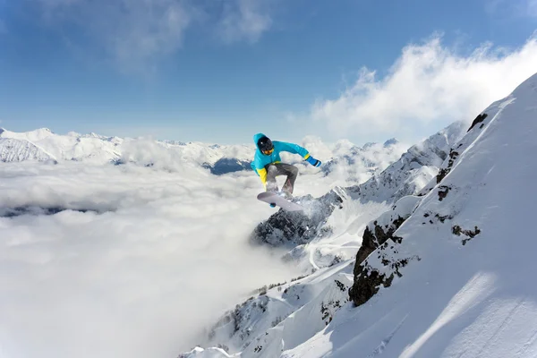 Snowboard jezdec skákat na horách. Extrémní snowboard freeride sport. — Stock fotografie