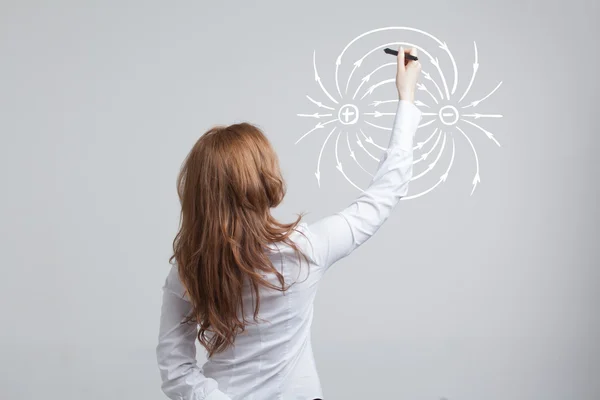 Mujer joven, profesora de física dibuja un diagrama del campo eléctrico — Foto de Stock