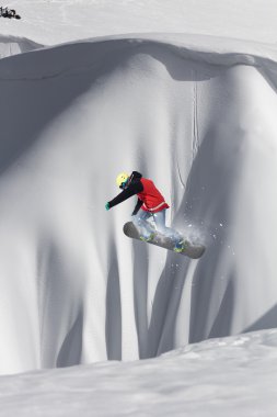 Dağlarda atlayan snowboard binicisi. Ekstrem snowboard serbest spor.