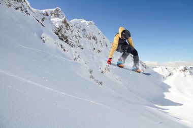Dağlarda atlayan snowboard binicisi. Ekstrem snowboard serbest spor.