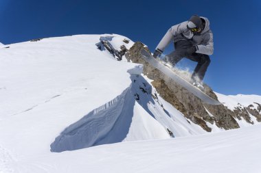 Dağlarda atlayan snowboard binicisi. Ekstrem snowboard serbest spor.