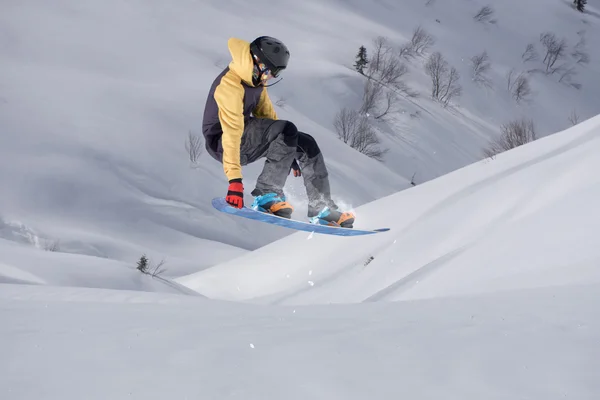 Snowboard lovas ugrál a hegyekben. Extrém snowboard freeride sport. — Stock Fotó