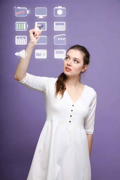 Woman pressing multimedia and entertainment icons on a virtual background — Stock Photo, Image