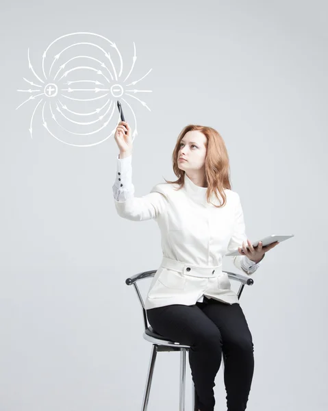 Jeune femme, professeur de physique dessine un diagramme du champ électrique — Photo