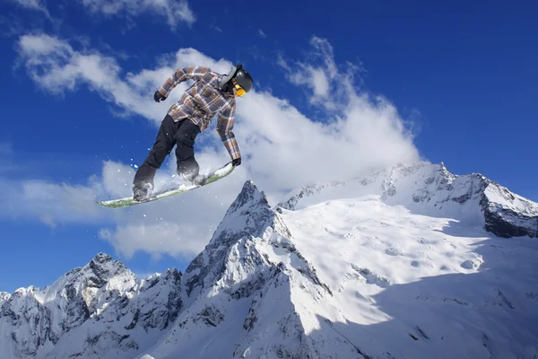 Cavaleiro de snowboard pulando em montanhas. Extremo esporte freeride . — Fotografia de Stock