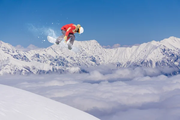 Cavaleiro de snowboard pulando em montanhas. Extremo esporte freeride . — Fotografia de Stock