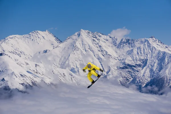 Cavaleiro de snowboard pulando em montanhas. Extremo esporte freeride . — Fotografia de Stock