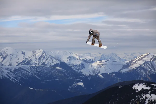 Snowboard rider skákání na horách. Extrémní freeride sport. — Stock fotografie
