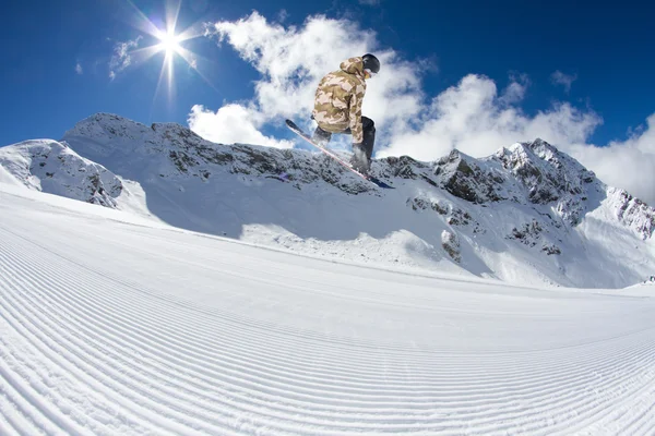 Cavaliere snowboard saltare sulle montagne. Sport freeride estremo . — Foto Stock