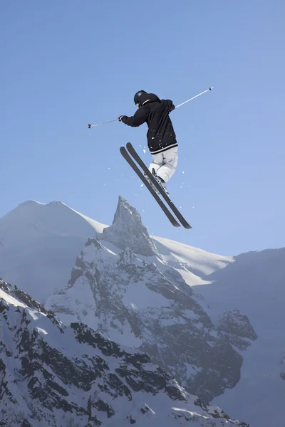 Cavaleiro de esqui a saltar sobre montanhas. Esporte de freeride de esqui extremo . — Fotografia de Stock