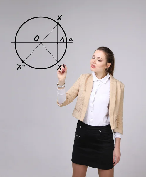 Vrouw met pen tekent geometrische vormen op grijze achtergrond — Stockfoto