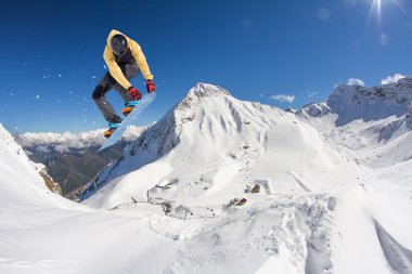 Dağlarda atlayan snowboard binicisi. Ekstrem snowboard serbest spor.