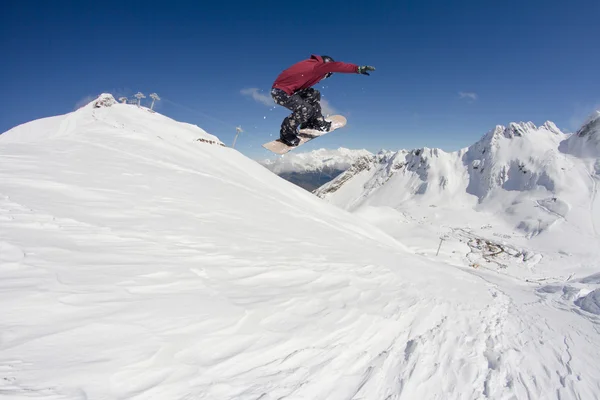 Dağlarda atlayan snowboard binicisi. Ekstrem snowboard serbest spor. — Stok fotoğraf