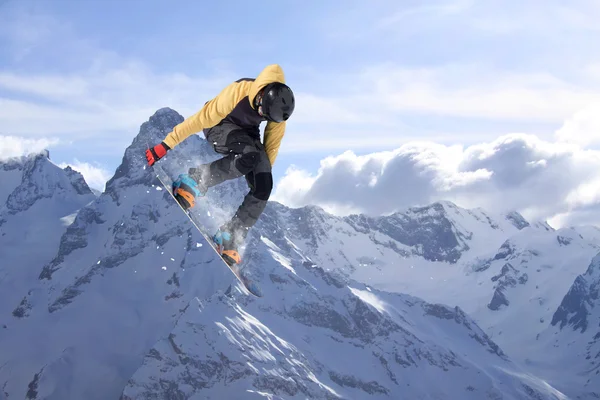 Сноубордист прыгает по горам. Экстремальный фрирайд на сноуборде. — стоковое фото