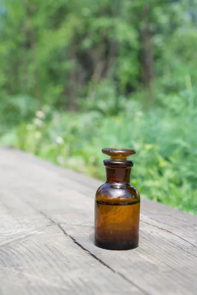 Flüssigkeit in chemischem Geschirr auf dem Hintergrund von Pflanzen, Düngemitteln oder Pestiziden im Garten. — Stockfoto