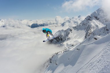 Dağlarda atlayan snowboard binicisi. Ekstrem snowboard serbest spor.