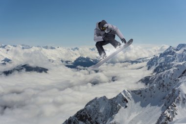 Dağlarda atlayan snowboard binicisi. Ekstrem snowboard serbest spor.