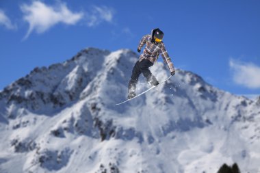 Dağlarda atlayan snowboard binicisi. Ekstrem snowboard serbest spor.