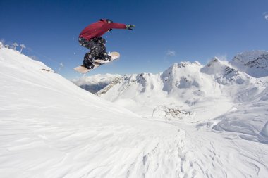 Dağlarda atlayan snowboard binicisi. Ekstrem snowboard serbest spor.