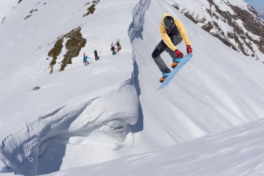 Dağlarda atlayan snowboard binicisi. Ekstrem snowboard serbest spor.