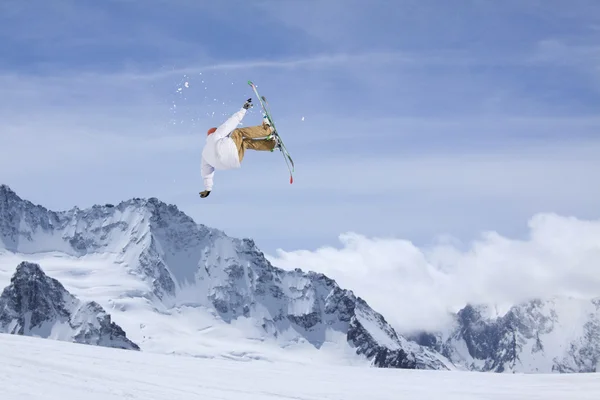 Cavaleiro de esqui a saltar sobre montanhas. Esporte de freeride de esqui extremo . — Fotografia de Stock