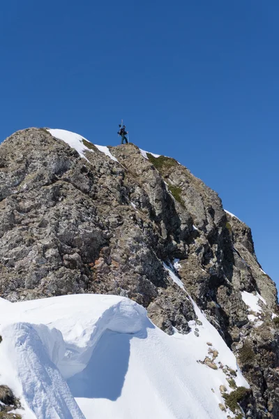 Homme avec snowboard au sommet d'une montagne, alpinisme extrême . — Photo