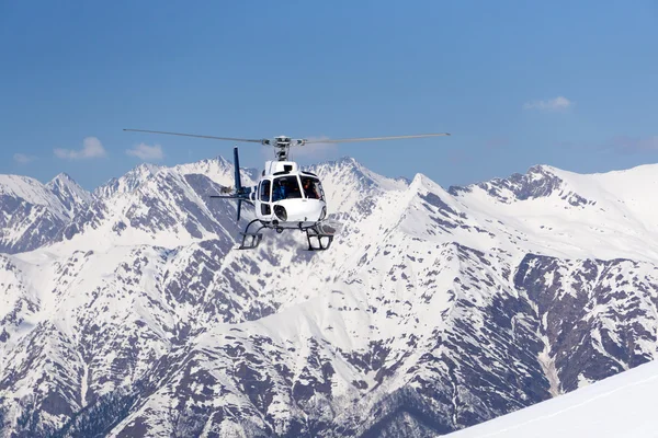 Beyaz kurtarma helikopteri dağlarda — Stok fotoğraf