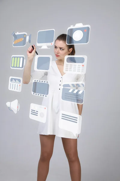 Woman pressing multimedia and entertainment icons on a virtual background — Stock Photo, Image