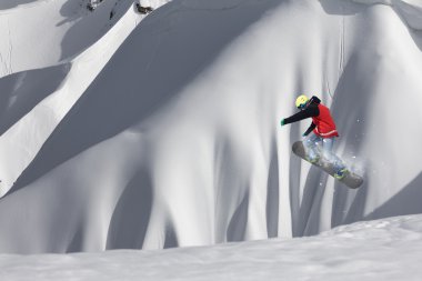Dağlarda atlayan snowboard binicisi. Ekstrem snowboard serbest spor.