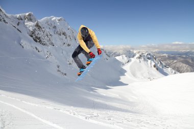Dağlarda atlayan snowboard binicisi. Ekstrem snowboard serbest spor.