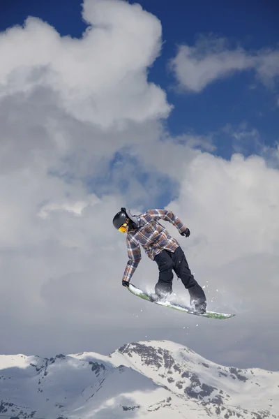 Snowboarder springt hoog in de bergen. — Stockfoto