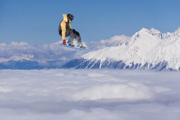 Snowboarder salta alto nas montanhas . — Fotografia de Stock