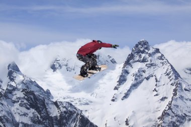 Snowboard yüksek dağlarda atlar.