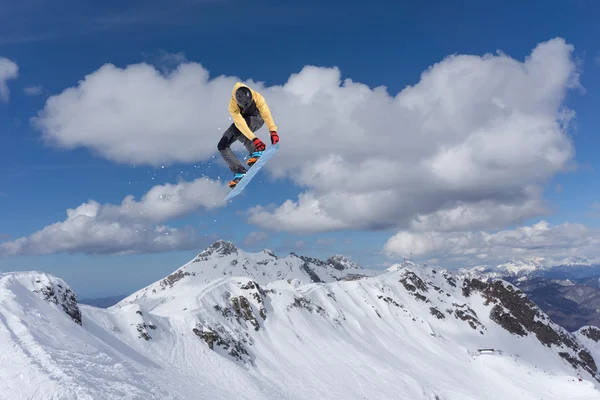 Snowboarder salta alto nas montanhas . — Fotografia de Stock