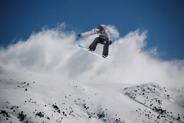 Snowboarder springt hoog in de bergen. — Stockfoto