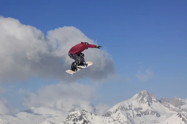 Snowboarder jumping in mountains, extreme sport. — Stockfoto