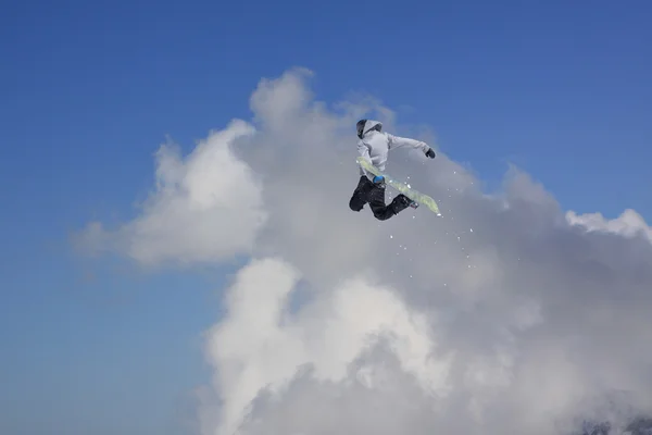 Ugrás a hegyek, extrém sport snowboardos. — Stock Fotó