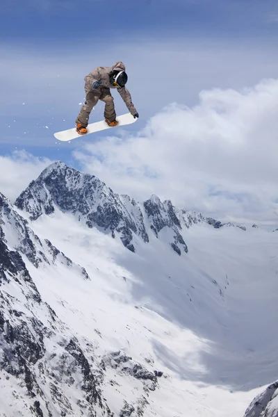 Ugrás a hegyek, extrém sport snowboardos. — Stock Fotó