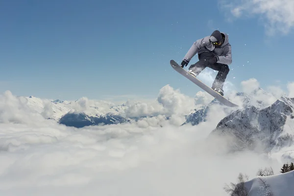 Snowboarder jumping in mountains, extreme sport. — Stock fotografie