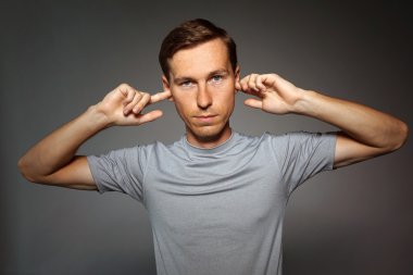 Genç adam onun kulaklarını parmak ile durdu.