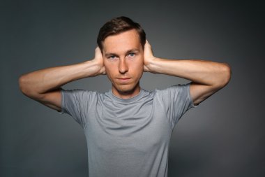 Genç adam onun kulaklarını elleriyle durdu.