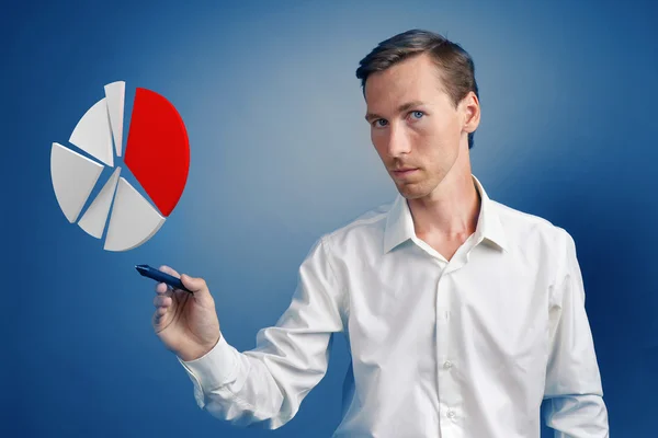 Homme en chemise blanche travaillant avec un graphique à secteurs sur fond bleu . — Photo