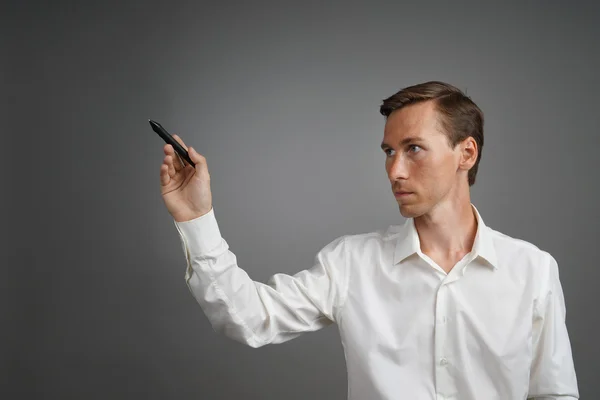 Mann schreibt etwas mit Filzstift auf Glasplatte. — Stockfoto