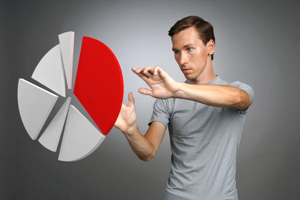 Hombre con camiseta trabajando con gráfico circular sobre fondo gris . —  Fotos de Stock