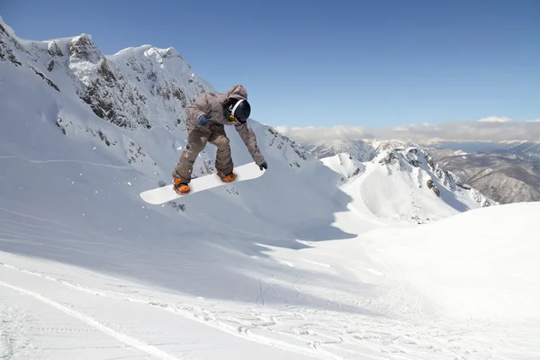 Snowboarder άλμα στα βουνά. Εξτριμ σπορ. — Φωτογραφία Αρχείου