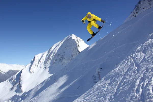 Snowboarder saltando sobre montañas. Deporte extremo . — Foto de Stock