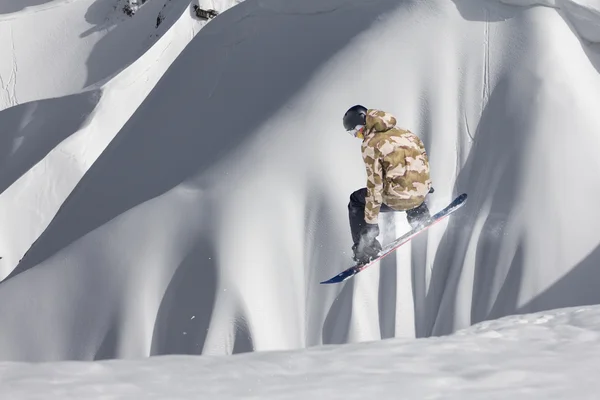 Snowboardåkare hoppa på bergen. Extrem sport. — Stockfoto